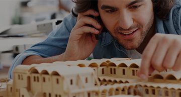 Architect working on a wooden prototype of a construction model