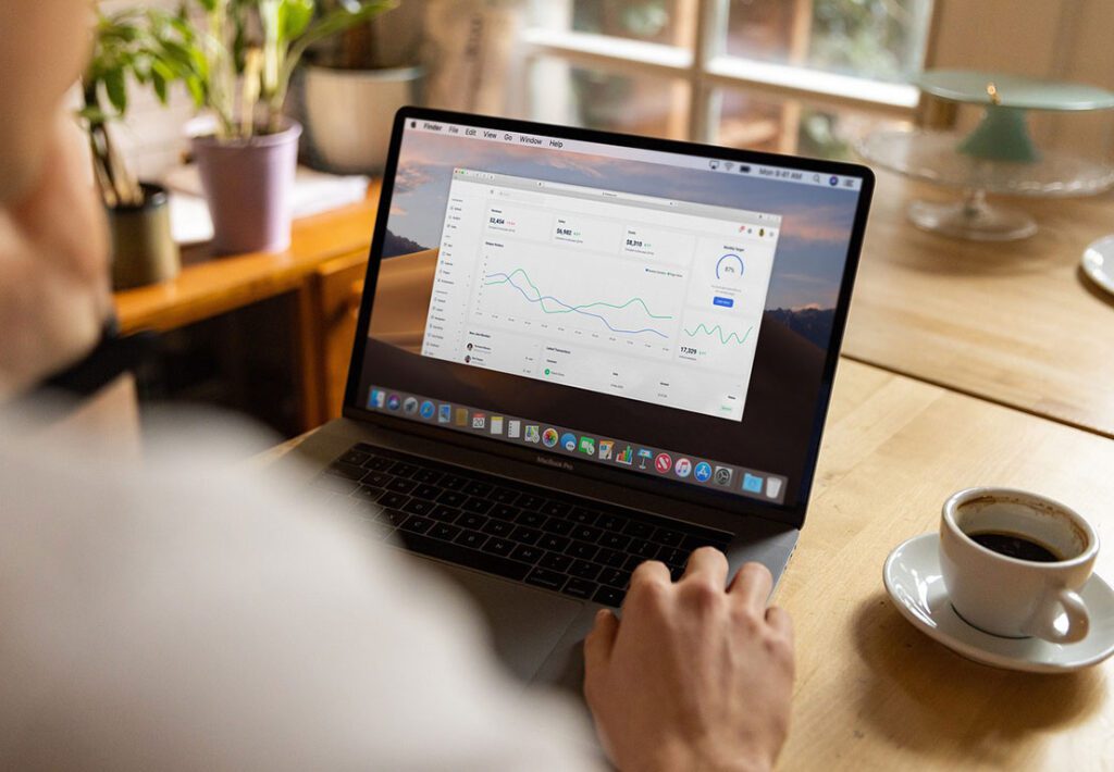 laptop and cup of coffee on a wooden table