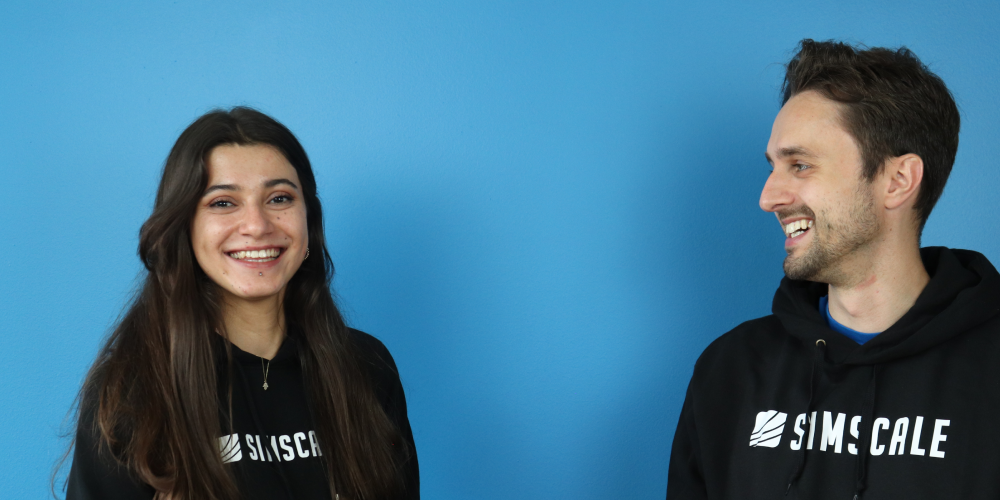 Two SimScale employees in SimScale hoodies laughing with each other